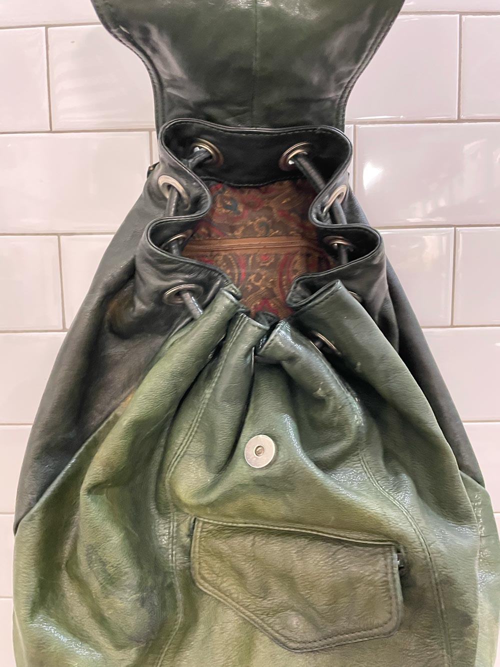 vintage sun-faded green leather backpack